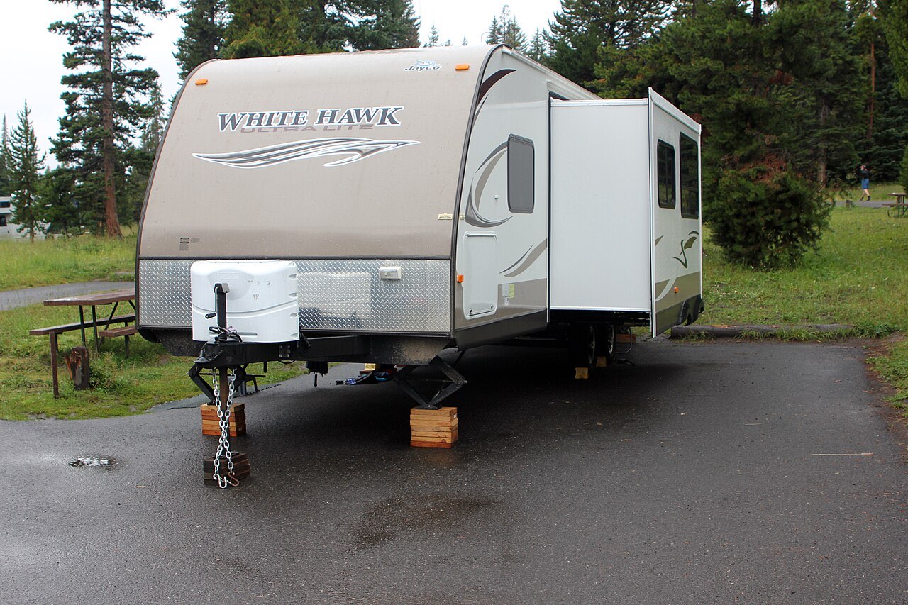 Empty paved back-in campsite with a picnic table among lodgepole pines at Bridge Bay Campground